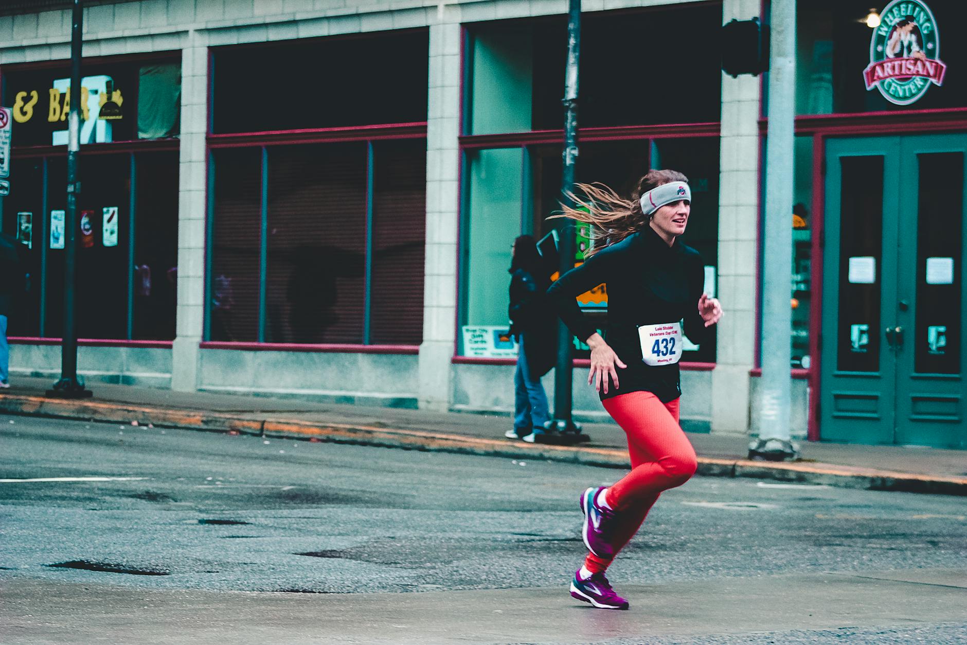 woman wearing red pants and black long sleeved top running